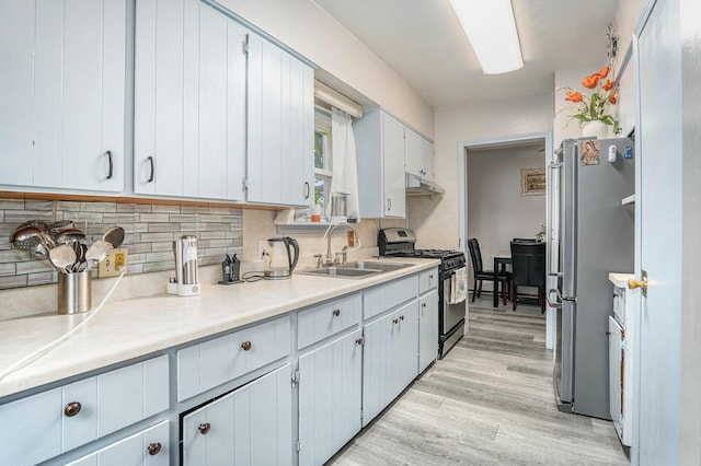 134 Honeoye St SW, Grand Rapids, MI 49548 - kitchen featuring appliances with stainless steel finishes, light wood-style floors, decorative backsplash, and light countertops
