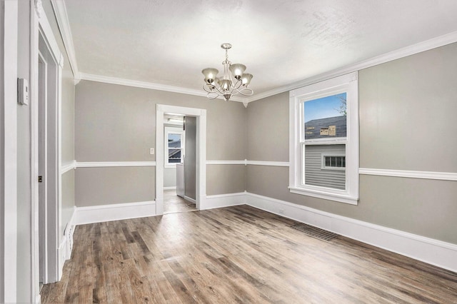 436 Quimby St NE, Grand Rapids, MI 49505 - unfurnished dining area featuring a chandelier, ornamental molding, and wood finished floors
