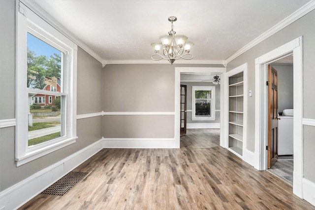 436 Quimby St NE, Grand Rapids, MI 49505 - unfurnished dining area featuring built in shelves, healthy amount of natural light, a chandelier, crown molding, and wood finished floors