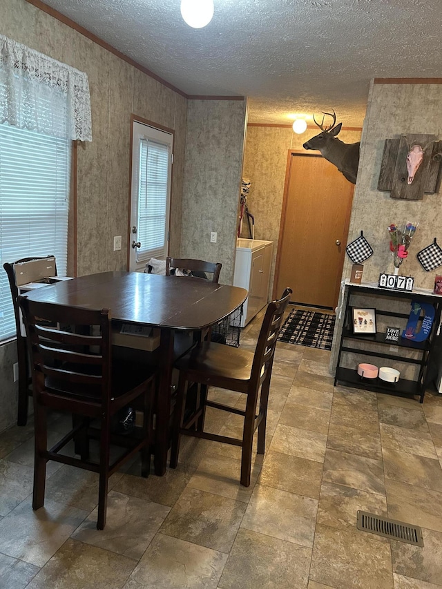 3728 Richardson St, Muskegon, MI 49442 - dining area featuring ornamental molding, a textured ceiling, and washer / clothes dryer