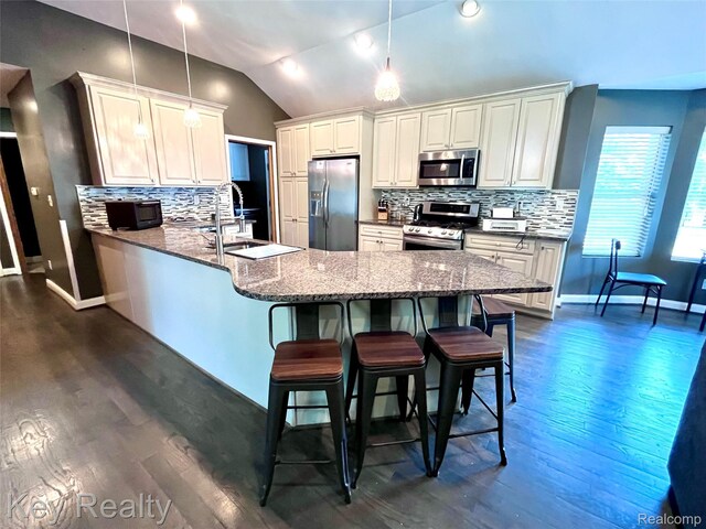 7949 Church Rd, Grosse Ile, MI 48138 - kitchen with stainless steel appliances, a peninsula, vaulted ceiling, dark wood-style floors, and tasteful backsplash