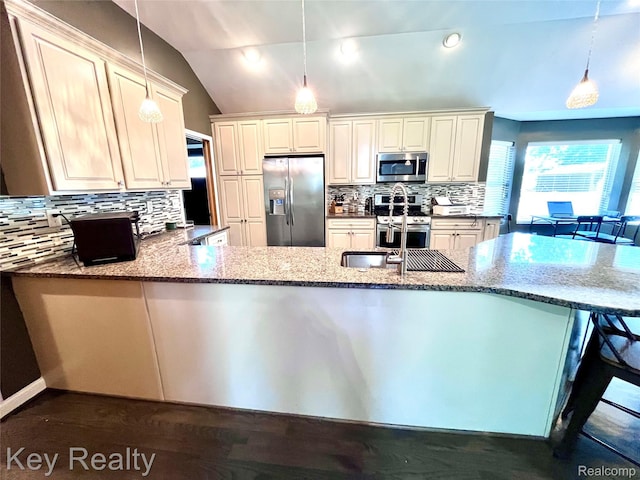 7949 Church Rd, Grosse Ile, MI 48138 - kitchen featuring appliances with stainless steel finishes, light stone countertops, backsplash, a peninsula, and vaulted ceiling