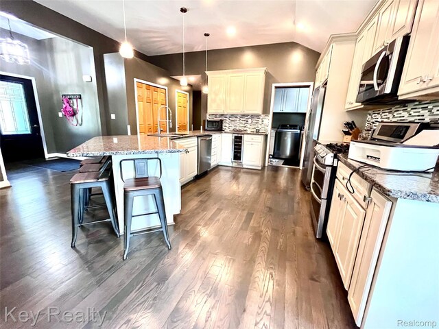 7949 Church Rd, Grosse Ile, MI 48138 - kitchen with appliances with stainless steel finishes, wine cooler, lofted ceiling, dark wood-style flooring, and tasteful backsplash