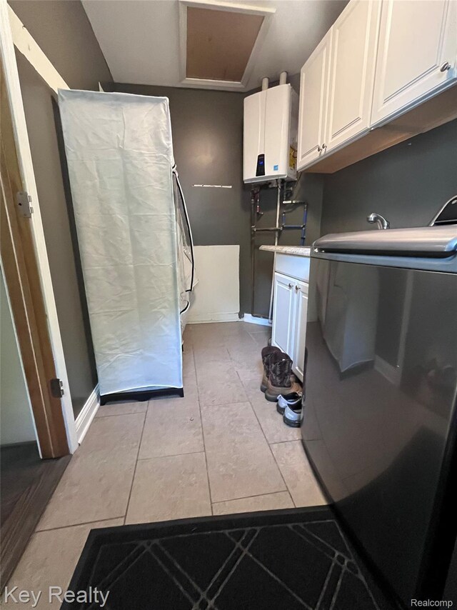 7949 Church Rd, Grosse Ile, MI 48138 - kitchen with tankless water heater, refrigerator, white cabinets, and light tile patterned floors