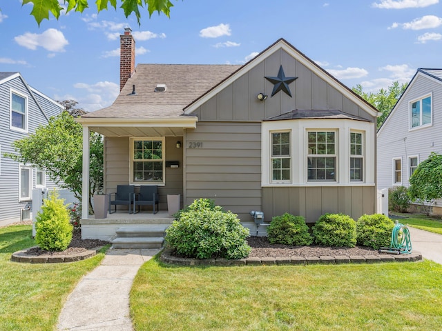 2391 Cambridge Rd, Berkley, MI 48072 - bungalow-style house with board and batten siding, a chimney, covered porch, and a front yard