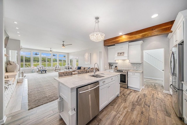 828 Russmiller Loop, Brooklyn, MI 49230 - kitchen with stainless steel appliances, open floor plan, a ceiling fan, light wood-type flooring, and white cabinetry
