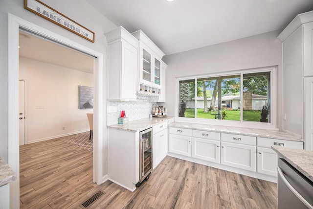 828 Russmiller Loop, Brooklyn, MI 49230 - kitchen with wine cooler, stainless steel dishwasher, white cabinetry, and light wood-style floors