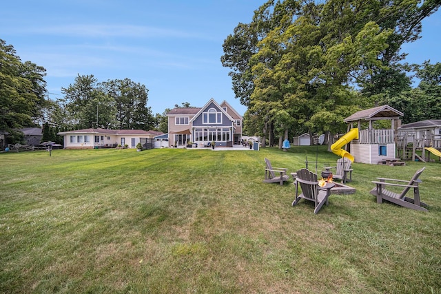 828 Russmiller Loop, Brooklyn, MI 49230 - view of grassy yard with a playground and an outdoor fire pit