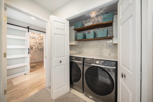 828 Russmiller Loop, Brooklyn, MI 49230 - washroom featuring independent washer and dryer, a barn door, and light wood finished floors