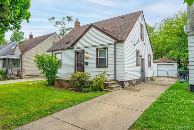 7768 Asbury Park, Dearborn, MI 48228 - view of front of home featuring a front yard, an outdoor structure, a detached garage, a gate, and a shingled roof