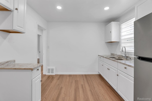 7768 Asbury Park, Dearborn, MI 48228 - kitchen with freestanding refrigerator, light wood-style flooring, white cabinetry, recessed lighting, and light countertops