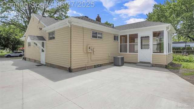 322 S Manitou Ave, Troy, MI 48017 - rear view of house featuring a shingled roof, a sunroom, a chimney, entry steps, and a patio area