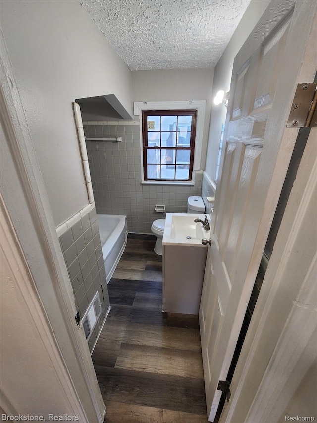 8428 Rosemont Ave, Dearborn Heights, MI 48228 - full bathroom featuring tile walls, vanity, wood finished floors, a textured ceiling, and a bathtub