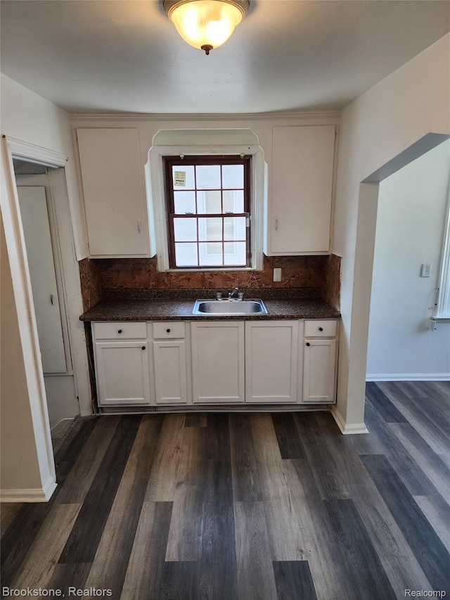 8428 Rosemont Ave, Dearborn Heights, MI 48228 - kitchen featuring dark countertops, dark wood-style floors, decorative backsplash, and white cabinets