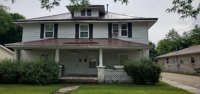 708 N Main St, Mount Pleasant, MI 48858 - american foursquare style home featuring covered porch, a metal roof, and a front yard