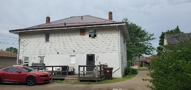 708 N Main St, Mount Pleasant, MI 48858 - rear view of house with a chimney and a wooden deck