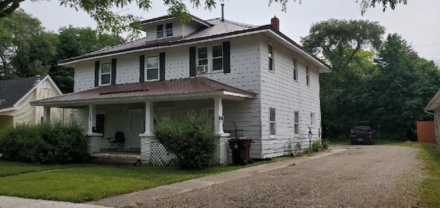 708 N Main St, Mount Pleasant, MI 48858 - traditional style home featuring covered porch, a chimney, a metal roof, and a front lawn
