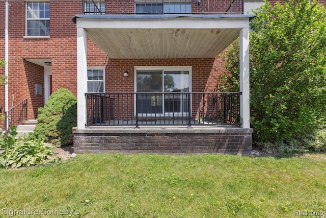 27671 W Echo Vly, Farmington Hills, MI 48334 - view of exterior entry with brick siding, a yard, and a porch