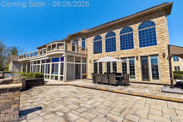 13229 Enid Blvd, Fenton, MI 48430 - back of house with a balcony, exterior kitchen, a patio, stone siding, and outdoor dining space