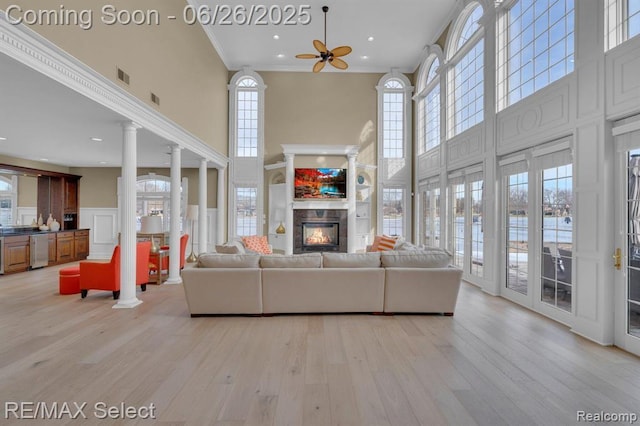 13229 Enid Blvd, Fenton, MI 48430 - living room featuring a high ceiling, a decorative wall, a tile fireplace, light wood-style flooring, and a ceiling fan