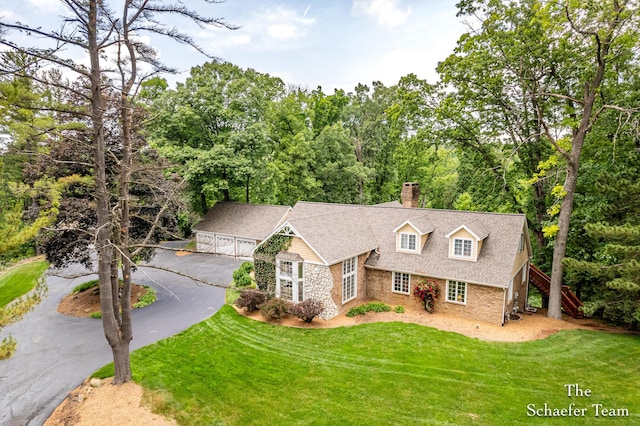 175 Honey Creek Ave NE, Ada, MI 49301 - view of front facade featuring a chimney, a front yard, asphalt driveway, a shingled roof, and stairway