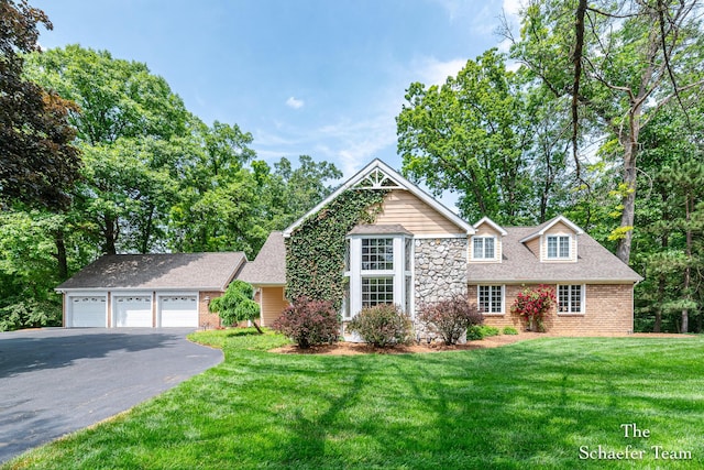 175 Honey Creek Ave NE, Ada, MI 49301 - view of front of home with driveway, a front yard, brick siding, an attached garage, and roof with shingles