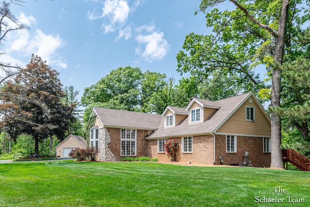 175 Honey Creek Ave NE, Ada, MI 49301 - view of front of home featuring a detached garage, a front yard, a shingled roof, and an outdoor structure