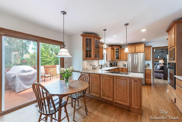 175 Honey Creek Ave NE, Ada, MI 49301 - kitchen featuring appliances with stainless steel finishes, light wood-style flooring, light countertops, brown cabinetry, and recessed lighting