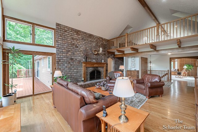 175 Honey Creek Ave NE, Ada, MI 49301 - living area with high vaulted ceiling, light wood finished floors, and a fireplace