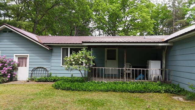 1686 Oak St, Wellston, MI 49689 - back of house with a porch, a metal roof, and a lawn