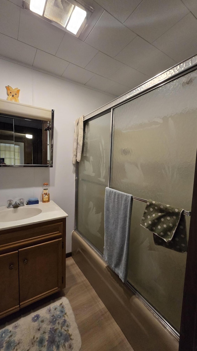1686 Oak St, Wellston, MI 49689 - bathroom featuring shower / bath combination with glass door, vanity, and wood finished floors