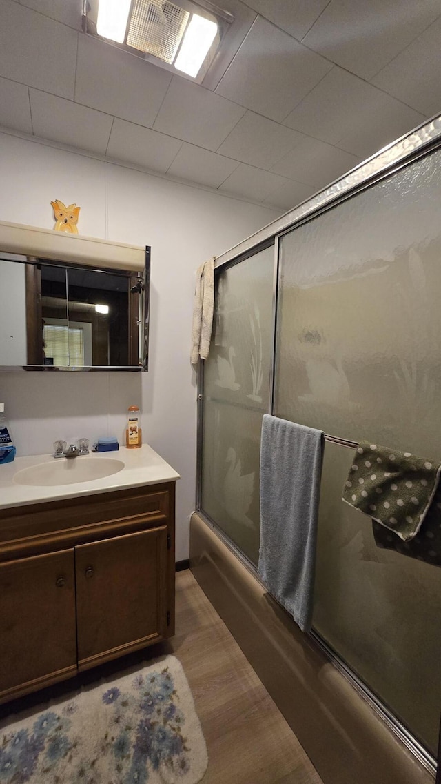 1686 Oak St, Wellston, MI 49689 - bathroom with enclosed tub / shower combo, vanity, and wood finished floors