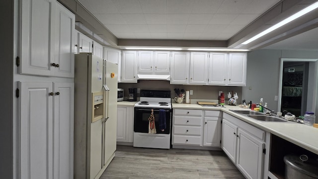 1686 Oak St, Wellston, MI 49689 - kitchen featuring white appliances, white cabinets, light wood-style flooring, extractor fan, and light countertops