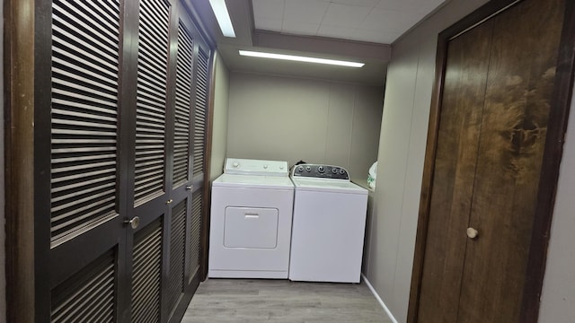 1686 Oak St, Wellston, MI 49689 - laundry room with washing machine and dryer, light wood finished floors, and a decorative wall