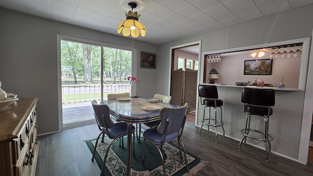 1686 Oak St, Wellston, MI 49689 - dining space featuring healthy amount of natural light, dark wood-style flooring, and bar area