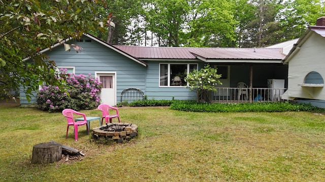 1686 Oak St, Wellston, MI 49689 - rear view of house featuring an outdoor fire pit, a yard, and a metal roof