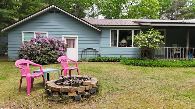 1686 Oak St, Wellston, MI 49689 - back of property with an outdoor fire pit, a yard, and a metal roof