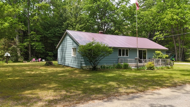 1686 Oak St, Wellston, MI 49689 - single story home with a front yard, a deck, a metal roof, and a chimney