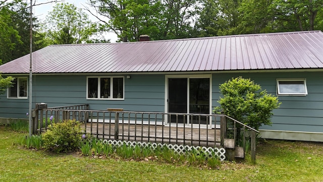 1686 Oak St, Wellston, MI 49689 - rear view of house with a metal roof, a wooden deck, a chimney, and a yard