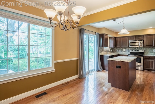 24475 Jamestowne Rd, Novi, MI 48375 - kitchen with stainless steel appliances, dark brown cabinetry, a center island, backsplash, and ornamental molding