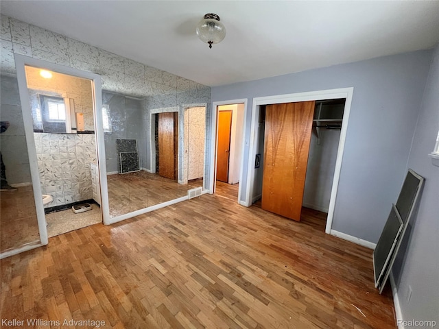 913 Cameron Ave, Pontiac, MI 48340 - unfurnished bedroom with wood finished floors and two closets