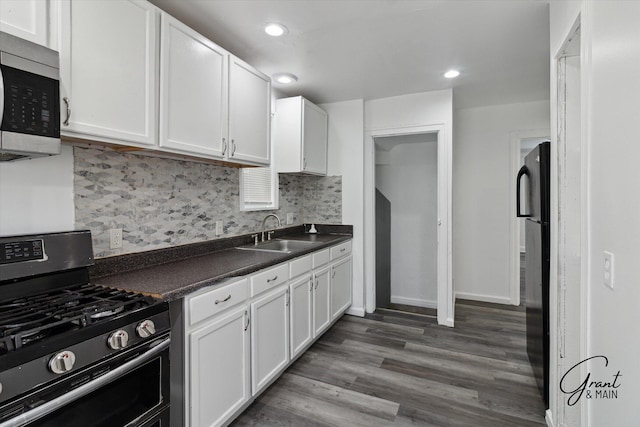 16630 Tracey St, Detroit, MI 48235 - kitchen with stainless steel appliances, dark countertops, white cabinets, backsplash, and recessed lighting