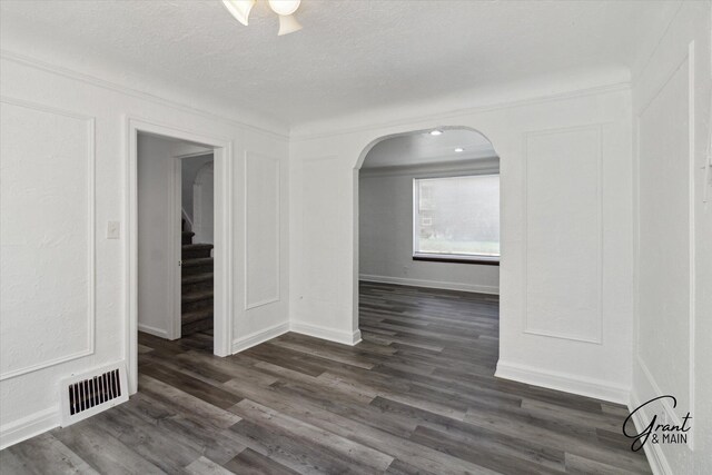 16630 Tracey St, Detroit, MI 48235 - unfurnished room featuring arched walkways, dark wood-style flooring, stairway, a textured ceiling, and ceiling fan