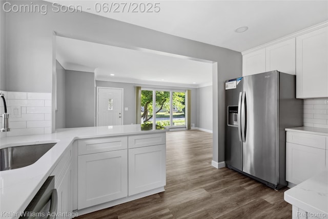 36669 Pinetree St, Livonia, MI 48150 - kitchen featuring appliances with stainless steel finishes, light stone countertops, backsplash, white cabinetry, and dark wood-style floors