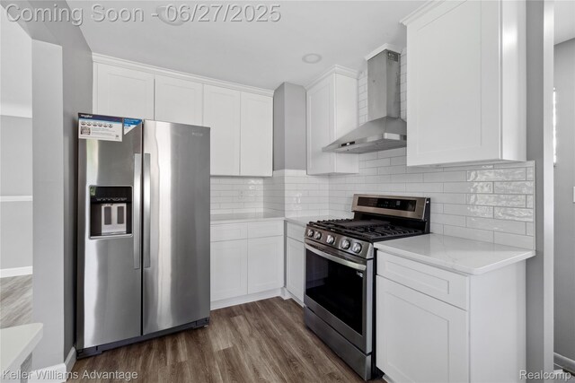 36669 Pinetree St, Livonia, MI 48150 - kitchen featuring appliances with stainless steel finishes, wall chimney exhaust hood, white cabinetry, dark wood-style floors, and tasteful backsplash