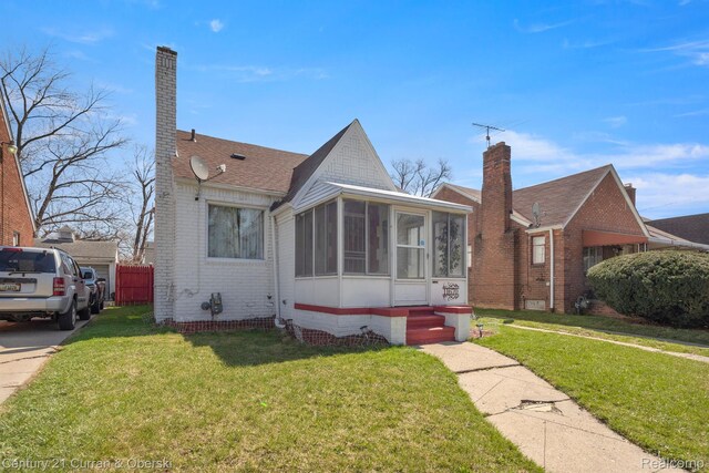 11670 Marlowe St, Detroit, MI 48227 - view of front of home featuring a sunroom, brick siding, a front lawn, and a chimney
