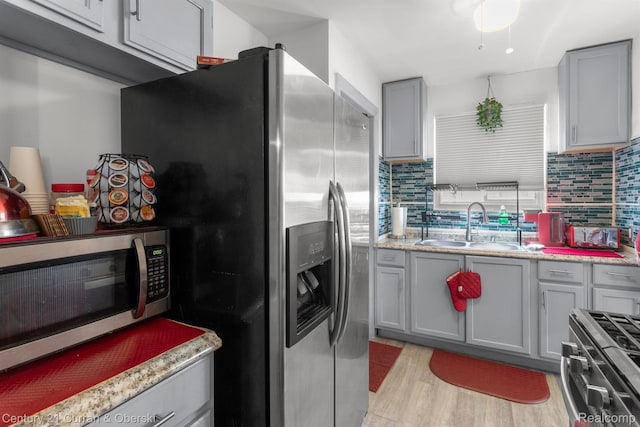 11670 Marlowe St, Detroit, MI 48227 - kitchen with stainless steel appliances, light wood-style flooring, backsplash, and gray cabinetry