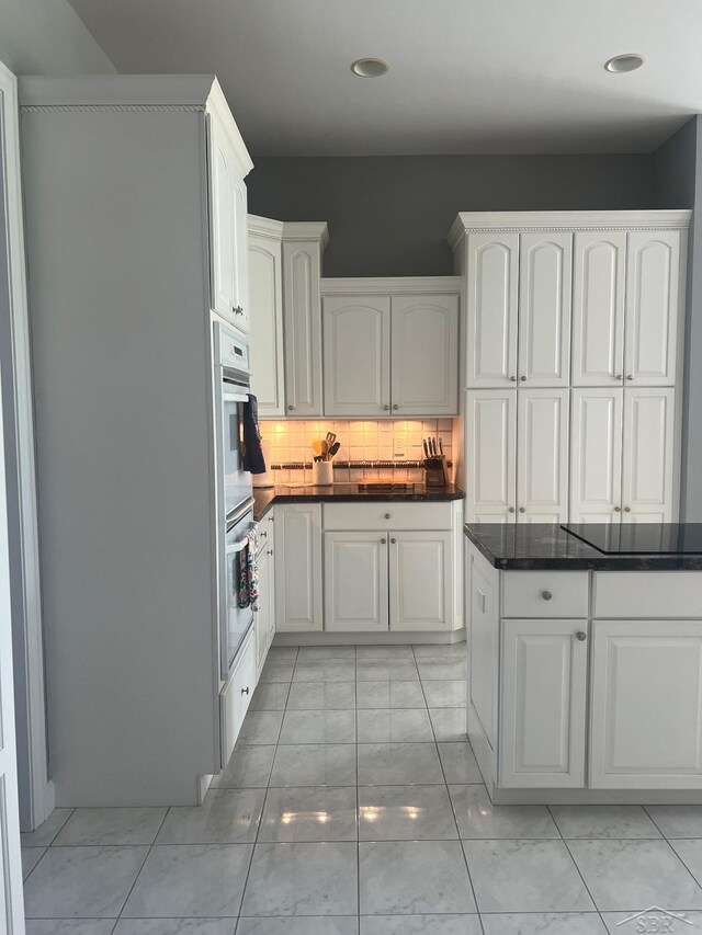 13 E Grove Ct, Freeland, MI 48623 - kitchen with dark countertops, decorative backsplash, white double oven, recessed lighting, and white cabinetry
