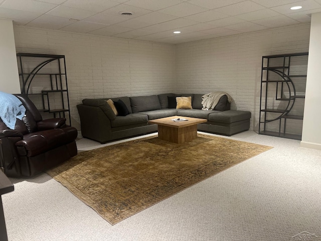 13 E Grove Ct, Freeland, MI 48623 - carpeted living room featuring brick wall and a paneled ceiling