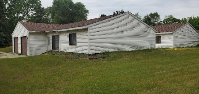 1000 W Lyons St, Mount Pleasant, MI 48858 - view of side of property with a garage, a yard, and concrete driveway